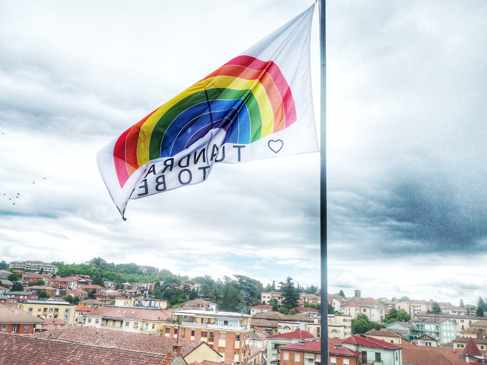 Una bandiera arcobaleno nel cielo di Acqui per dire che #andràtuttobene