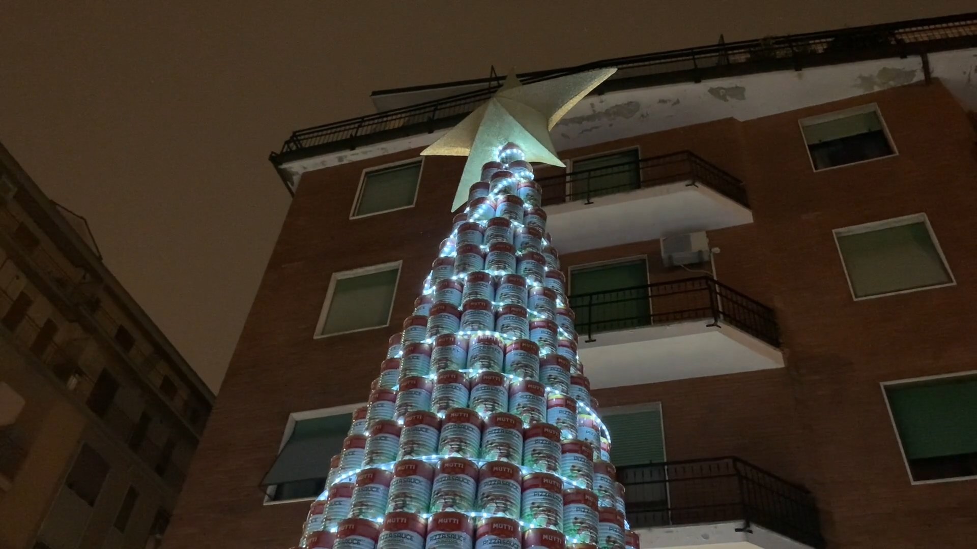 Piramide di barattoli per accendere il Natale: torna l’albero della pizzeria Soleluna