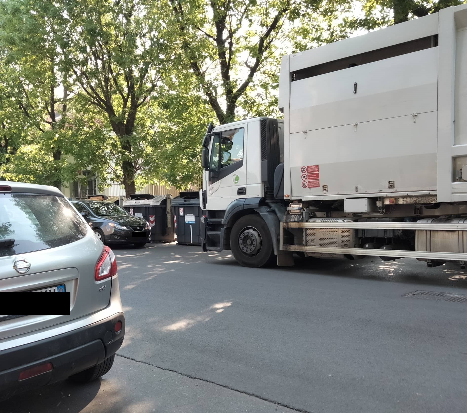 Quando il parcheggio selvaggio impedisce il lavoro degli altri: auto davanti ai bidoni e camion bloccato
