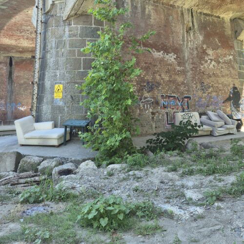 Divani, poltrone e un tavolino abbandonati sotto il ponte Bormida ad Alessandria