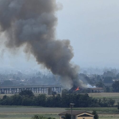 Fiamme in un fienile: densa colonna di fumo nera vicino all’autostrada